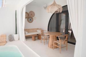 uma sala de estar com mesa e cadeiras em Bohemian Jogja Villas with Private Pool em Kejayan