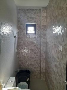 La salle de bains est pourvue d'une douche, de toilettes et d'une fenêtre. dans l'établissement Pozorrubio Apartment, à Pozorrubio