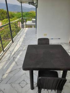 d'une table noire et de deux chaises sur un balcon. dans l'établissement Pozorrubio Apartment, à Pozorrubio