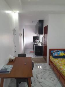 Zimmer mit einem Schreibtisch, einem Bett und einem Tisch in der Unterkunft Pozorrubio Apartment in Pozorrubio