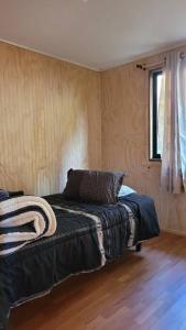 - une chambre avec un lit dans un dortoir doté de parquet dans l'établissement Cabaña Mirador del Valle, à Melipeuco