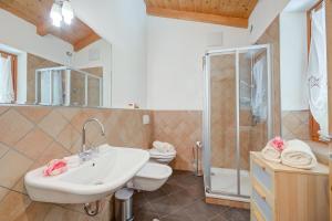 Un baño con lavabo, inodoro y ducha. en Casa Tra Borgo e Lago - Happy Rentals, en Tenno 24 fotos más