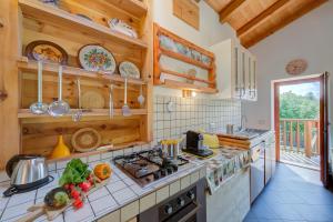Una cocina con gabinetes de madera y un horno de estufa. en Casa Tra Borgo e Lago - Happy Rentals, en Tenno