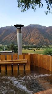 une masse d'eau avec une clôture en bois et une fontaine dans l'établissement Cabaña Mirador del Valle, à Melipeuco