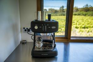 a black coffee maker sitting on a counter next to a window at The Treehouse at Sellicks Hill in Sellicks Hill
