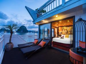 a bedroom on a boat with a bed and a balcony at Hera Cruises Group on Ha Long Bay in Ha Long