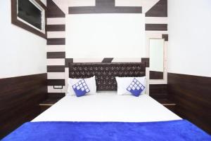 een slaapkamer met een bed met blauwe en witte lakens bij GRG Ashiyana Palace Parade Kothi Road Varanasi in Varanasi