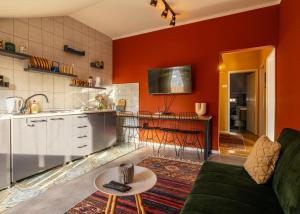 a living room with orange walls and a green couch at Cozy Main Square Apartment in Pristina