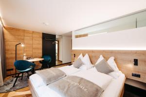 a bedroom with a white bed and a table at Sonne 1806 - Hotel am Campus Dornbirn in Dornbirn