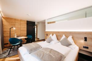 una camera con un letto bianco e un tavolo di Sonne 1806 - Hotel am Campus Dornbirn a Dornbirn