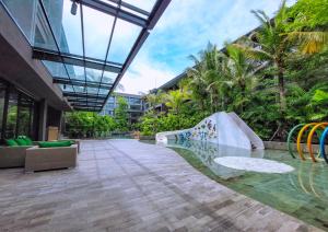 un edificio con piscina con tobogán y árboles en Pearl Nusa Dua Suite, en Nusa Dua