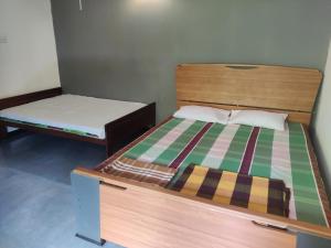 two twin beds in a room with a bed and a mattress at Enoch Guest House in Mannar