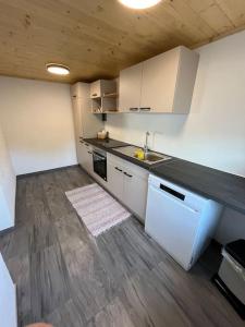 a kitchen with white appliances and a wooden floor at Meranerhof in Julbach