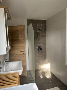 a bathroom with a shower and a sink and a tub at Meranerhof in Julbach