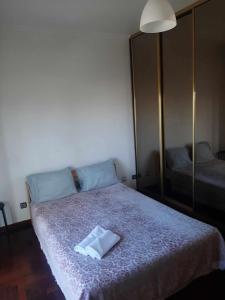 een slaapkamer met een bed met een witte handdoek erop bij Room THAYS KHAYS in Seixal