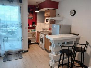 een keuken met een aanrecht en 2 barkrukken bij Agréable et tranquille studio vue mer in Saint-Denis