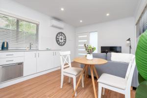 a kitchen and living room with a table and chairs at Cosy 1 BR unit in Ainslie in Canberra