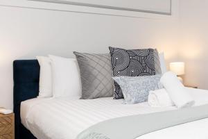 a white bed with pillows on top of it at Cosy 1 BR unit in Ainslie in Canberra