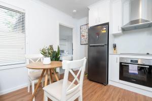 a kitchen with a table and a stainless steel refrigerator at Cosy 1 BR unit in Ainslie in Canberra