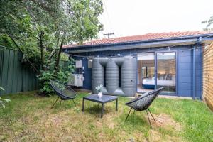 two chairs and a table in a yard with a house at Cosy 1 BR unit in Ainslie in Canberra