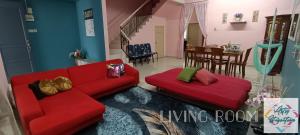a living room with a red couch and a dining room at Artsy Staycation in Melaka
