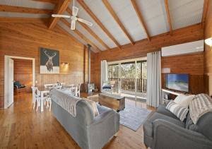 een woonkamer met 2 banken en een eetkamer bij North Lodge Clan Cottage in Pokolbin