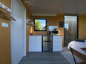 una pequeña cocina con fregadero y microondas en Forest Farm Tiny House, en Tauranga