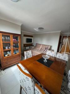 uma sala de estar com uma mesa de madeira e cadeiras em Apartamento St. Pedro Ludovico em Goiânia