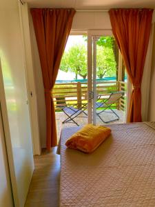 a bedroom with a bed and a door to a porch at Campeggio della Colombaia in Padenghe sul Garda +147 photos