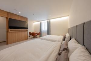 a hotel room with a large bed and a flat screen tv at H-avenue Hotel Munhyeon in Busan