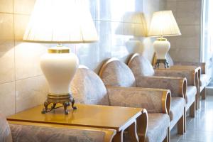 松本市にあるホテルモンターニュ松本のソファとテーブルの上にランプが備わる待合室