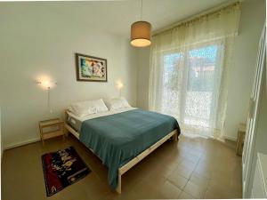 a bedroom with a bed and a large window at Refreshing villa with private garden near the beach in Porto Santa Margherita di Caorle