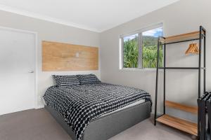 a bedroom with a bed and a window at Pearl's Embrace - Mangawhai Heads Studio in Mangawhai