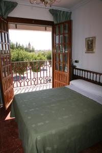 1 dormitorio con 1 cama junto a un balcón en Hostal Santa Barbara, en Socuéllamos