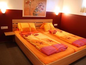 two twin beds in a bedroom with orange sheets at Spacious Chalet in Piesendorf with Sauna in Dürnberg