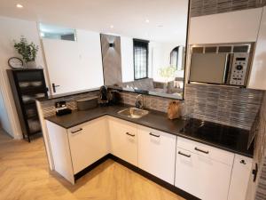 a kitchen with a sink and a microwave at Luxury bungalow for 6 people in Zevenhuizen