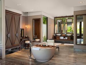 a bathroom with a bath tub and a sink at Jumeirah Bali in Uluwatu