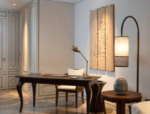 a desk with a lamp and chairs in a room at Jumeirah Bali in Uluwatu