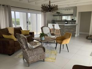a living room with a couch and chairs and a table at Sunshine Modern Retreat in Port Alfred