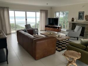 a living room with a couch and a television at Sunshine Modern Retreat in Port Alfred