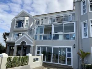 a white house with large windows at Sunshine Modern Retreat in Port Alfred