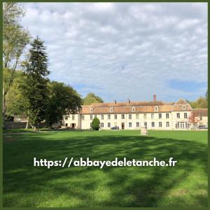 にあるAbbaye de l'Etanche - 2 chambres d'hôtes - Un cadre naturel exceptionnel -の大草原を前に広い建物