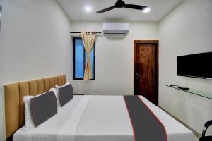 Hotel G.N Palace في كولْكاتا: غرفة نوم بسرير وتلفزيون بشاشة مسطحة