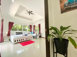 a bedroom with a white bed and a potted plant at Chalong - 4 Bedroom Private Pool Villa - Phuket in Chalong