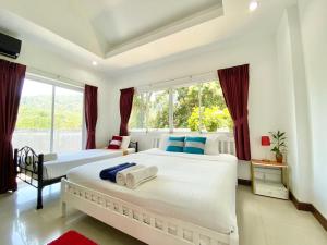 a bedroom with two beds and a large window at Phikun 4 BR Private Pool Villa in Chalong 