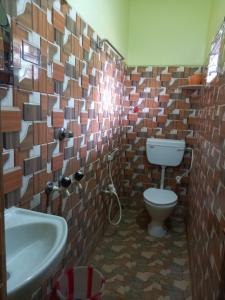 ein Bad mit einem WC und einem Waschbecken in der Unterkunft ATITHYA GUEST HOUSE in Srī Niketan
