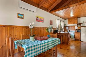 uma cozinha com uma mesa com uma toalha de mesa xadrez em StayAU Birchwood Cottage 2BR Yarra Valley Cottage em Badger Creek