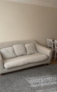 a white couch sitting in a living room at Wembley Stadium in London