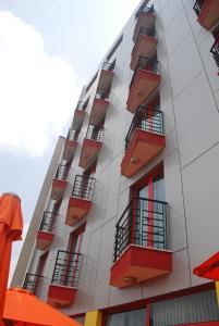 a tall apartment building with red balconies on it at Wassamar Hotel in Addis Ababa