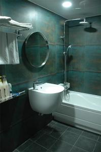 a bathroom with a sink and a tub and a mirror at Prince hotel in Goseong